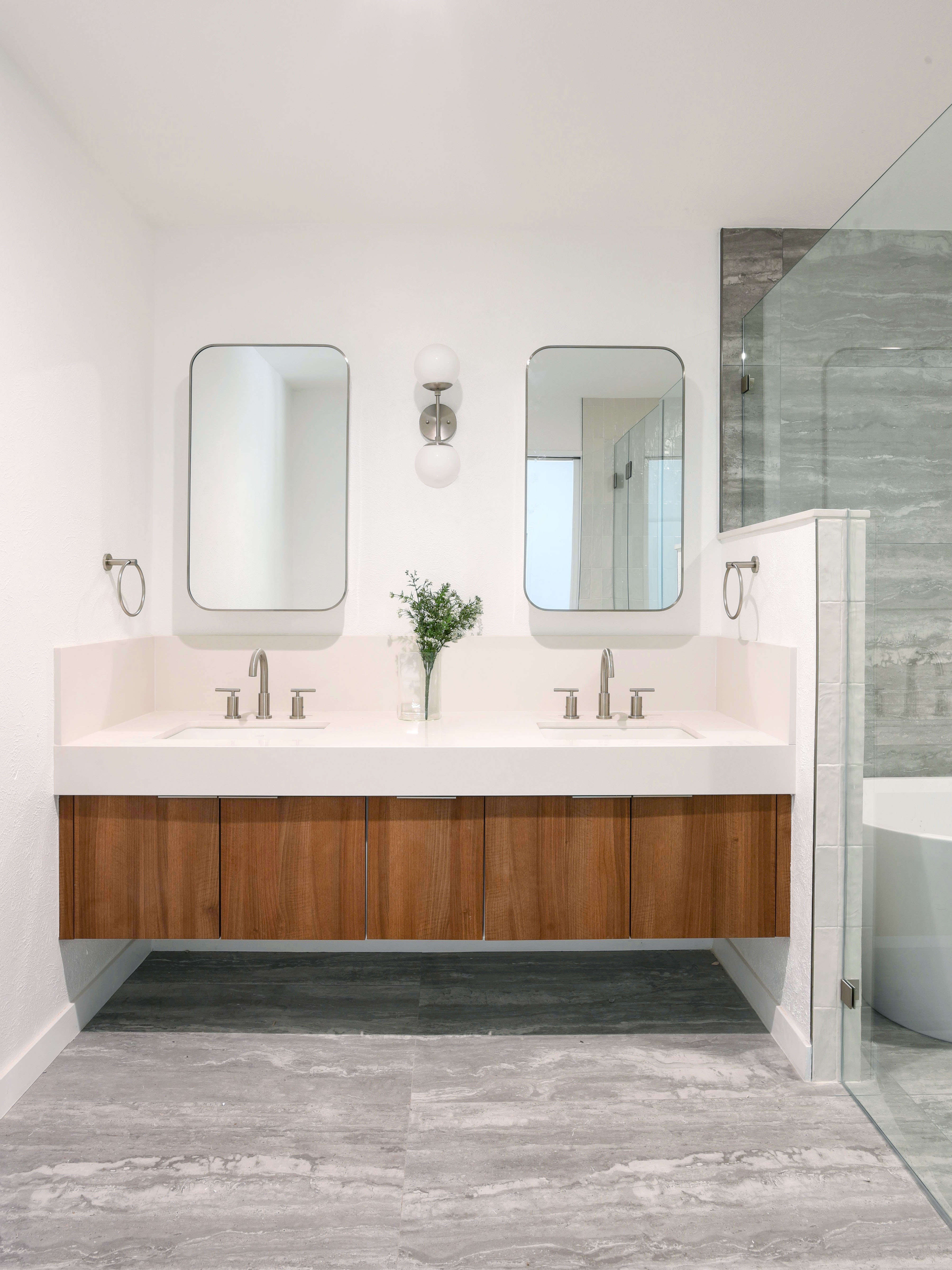 Minimalist bathroom with clean double vanity, warm walnut cabinets, and uncluttered surfaces