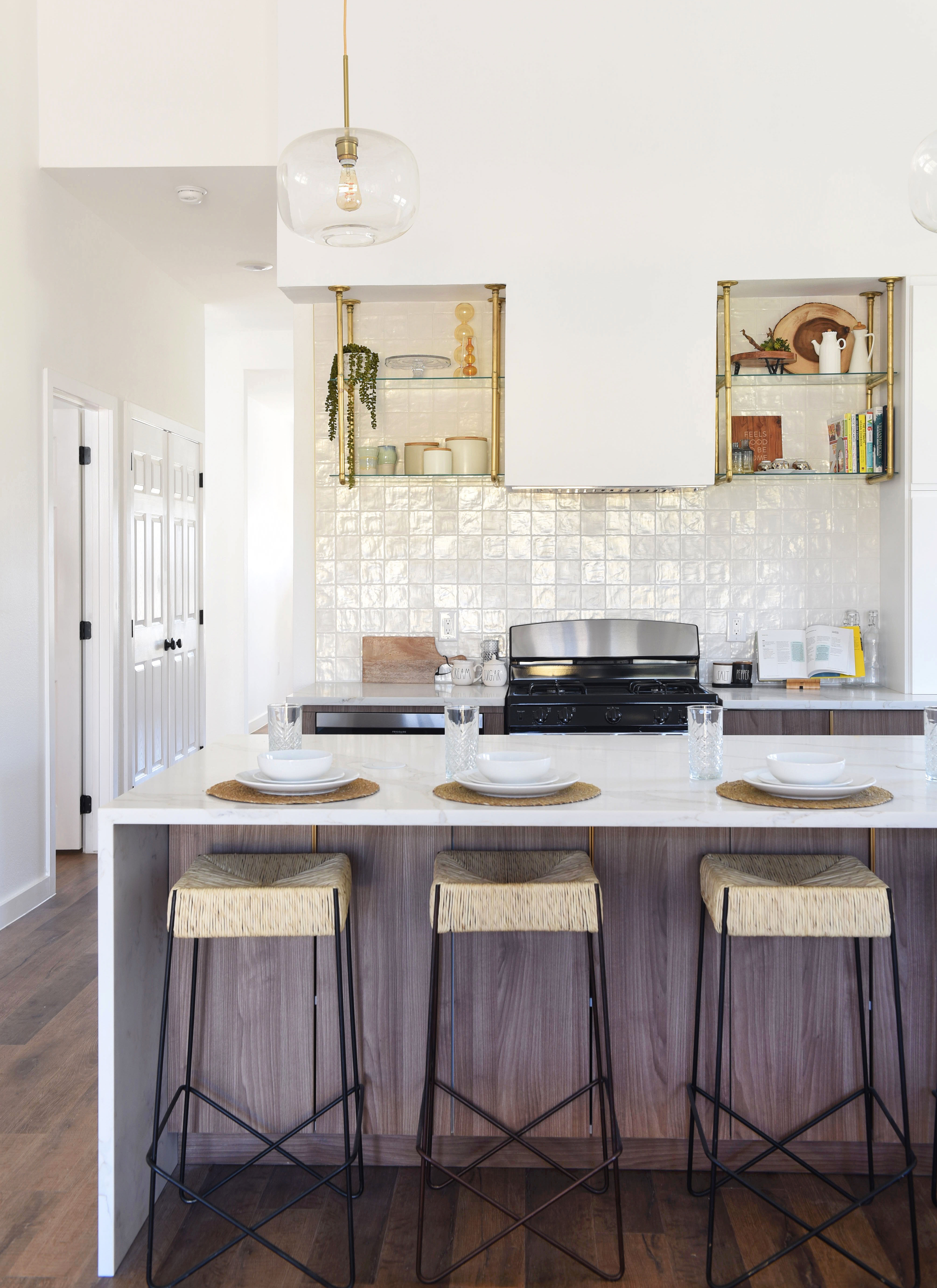 Modern kitchen with a statement brass pendant light and open shelving as the premium anchor